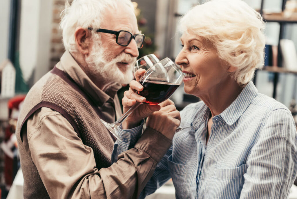The Philomena | Senior couple crossing their arms and sipping wine