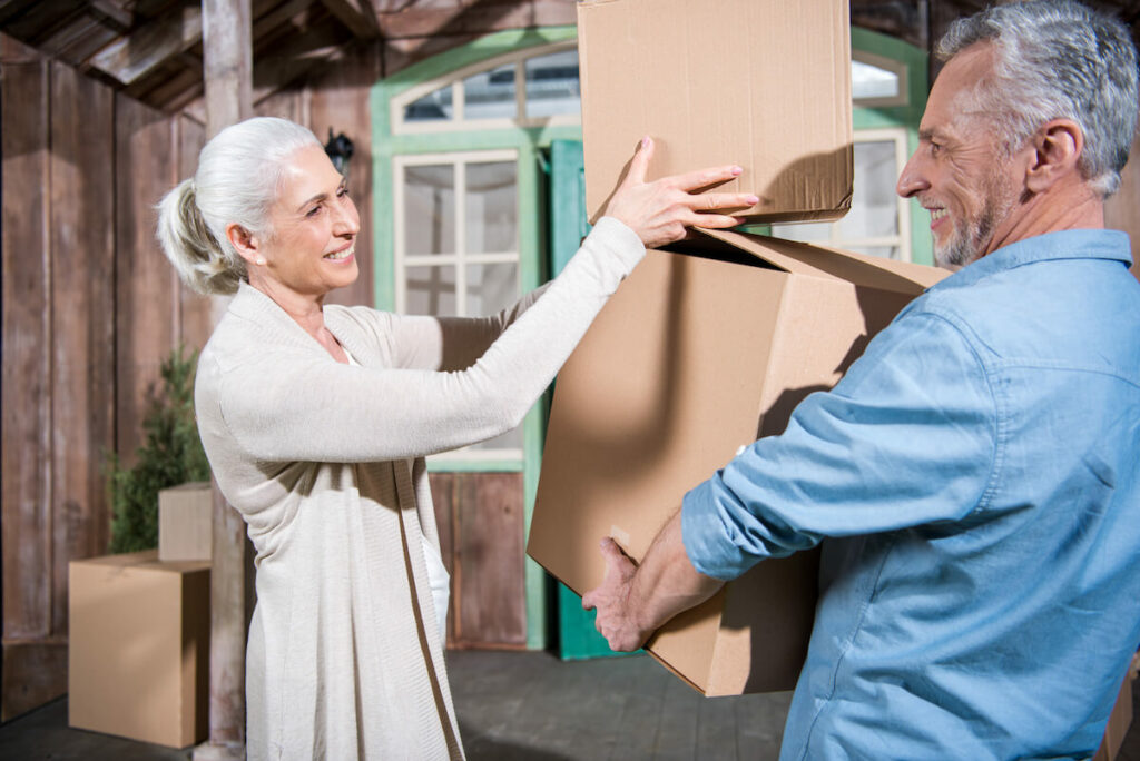 The Philomena | Seniors holding moving boxes